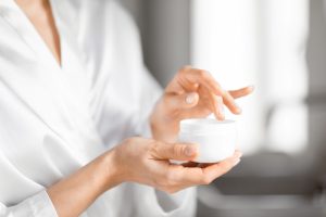 Femeie pregatindu-se sa aplice o crema pentru piele sensibila